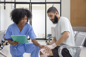 African nurse is examining tendinitis on knee injury from sport accident in Middle East patient for treatment and rehabilitation