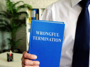 Wrongful termination. The employee holds a book in his hands.