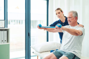Physiotherapy doctor, senior patient and band for stretching, physical therapy and orthopedic health. Physiotherapist, chiropractor and nurse help elderly man, osteoporosis and surgery rehabilitation